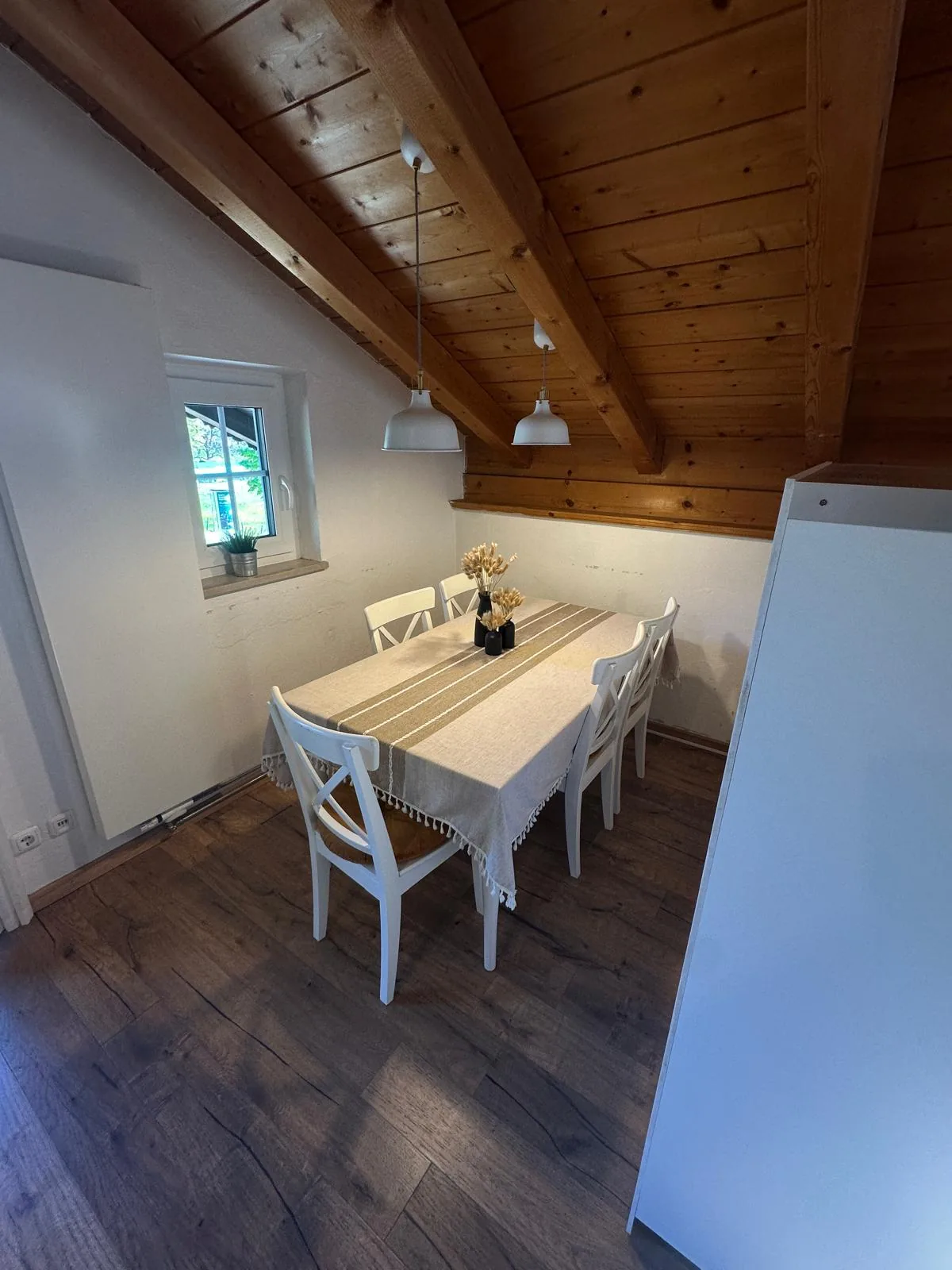 Offener Wohn- und Essbereich der Ferienwohnung Schafkopfblick mit Holzbalken