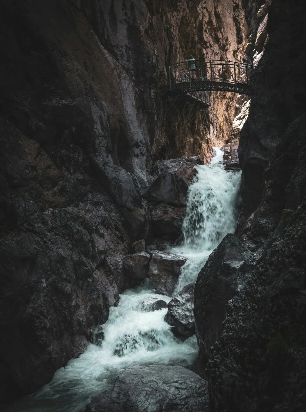 Wanderer auf dem Steg durch die Partnachklamm bei Garmisch-Partenkirchen